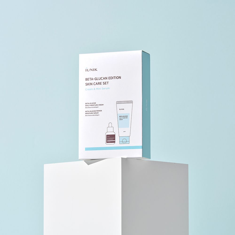 Emballage du produit sur un piédestal blanc. La boîte montre une illustration de crème et sérum. Marque iUNIK, nom du produit Beta-Glucan Edition.