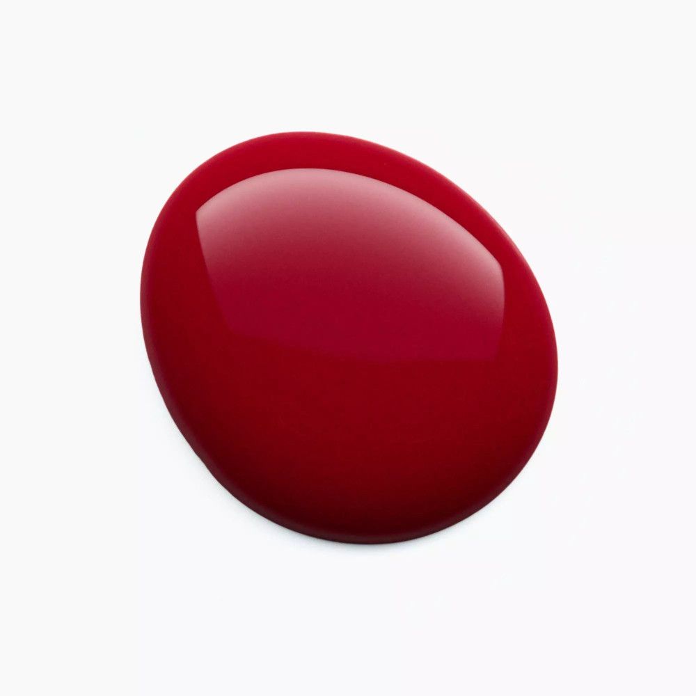 Goutte de vernis à ongles rouge sur fond blanc. Surface brillante.