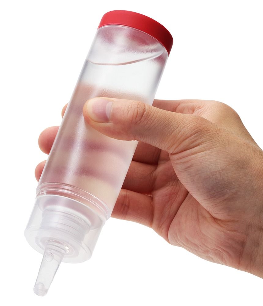 Main tenant une bouteille transparente de Tenga Hole Lotion Regular avec un bouchon rouge.