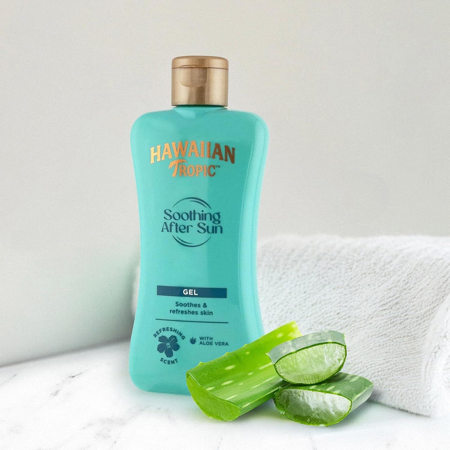 Flacon turquoise Hawaiian Tropic Soothing After Sun Gel à l'aloe vera. Comprend des tranches d'aloe vera et une serviette.