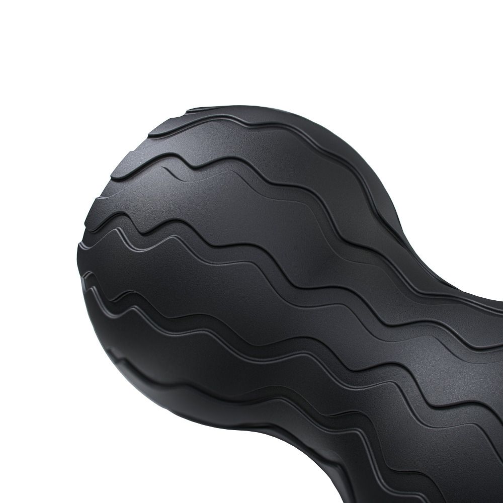 Close-up van de zwarte Wave Duo vibratiemassagebal. Golfvormig oppervlak. Geen andere details zichtbaar.