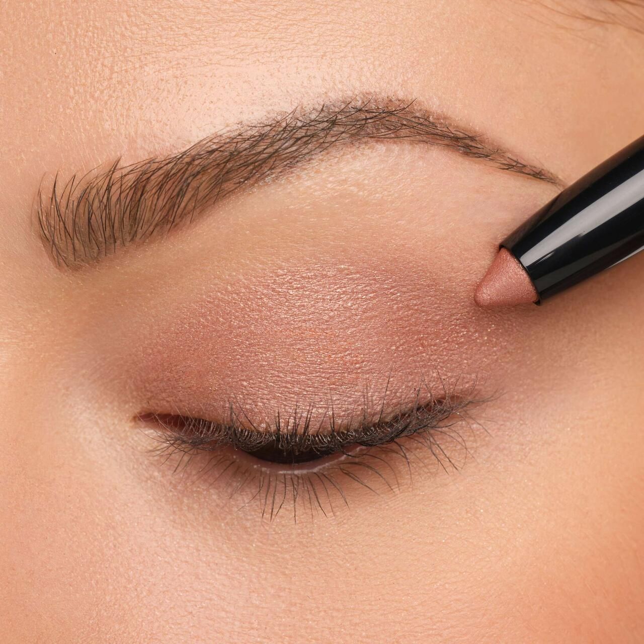 Oog met aangebrachte Artdeco High Performance Eyeshadow Stylo. Roze oogschaduw.