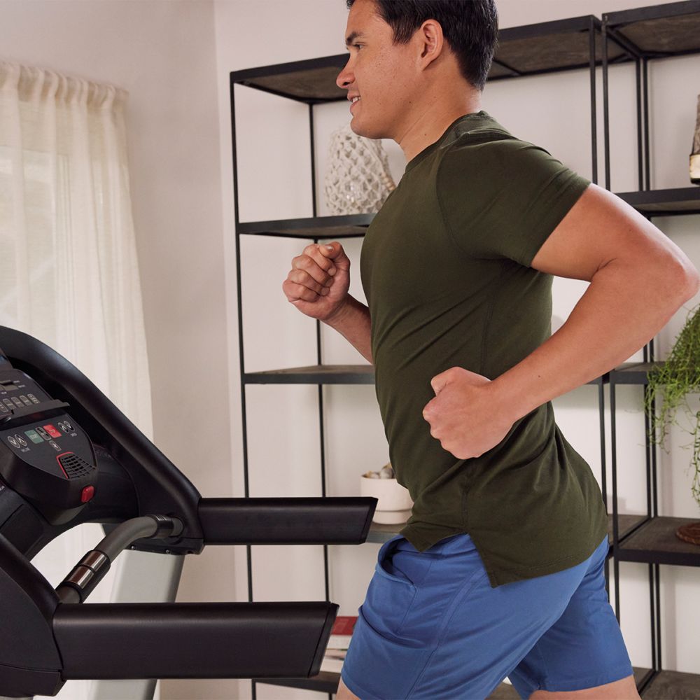 Man die op een loopband rent. Zwarte loopband, grijs frame. Schwinn Fitness SFT 3.5.