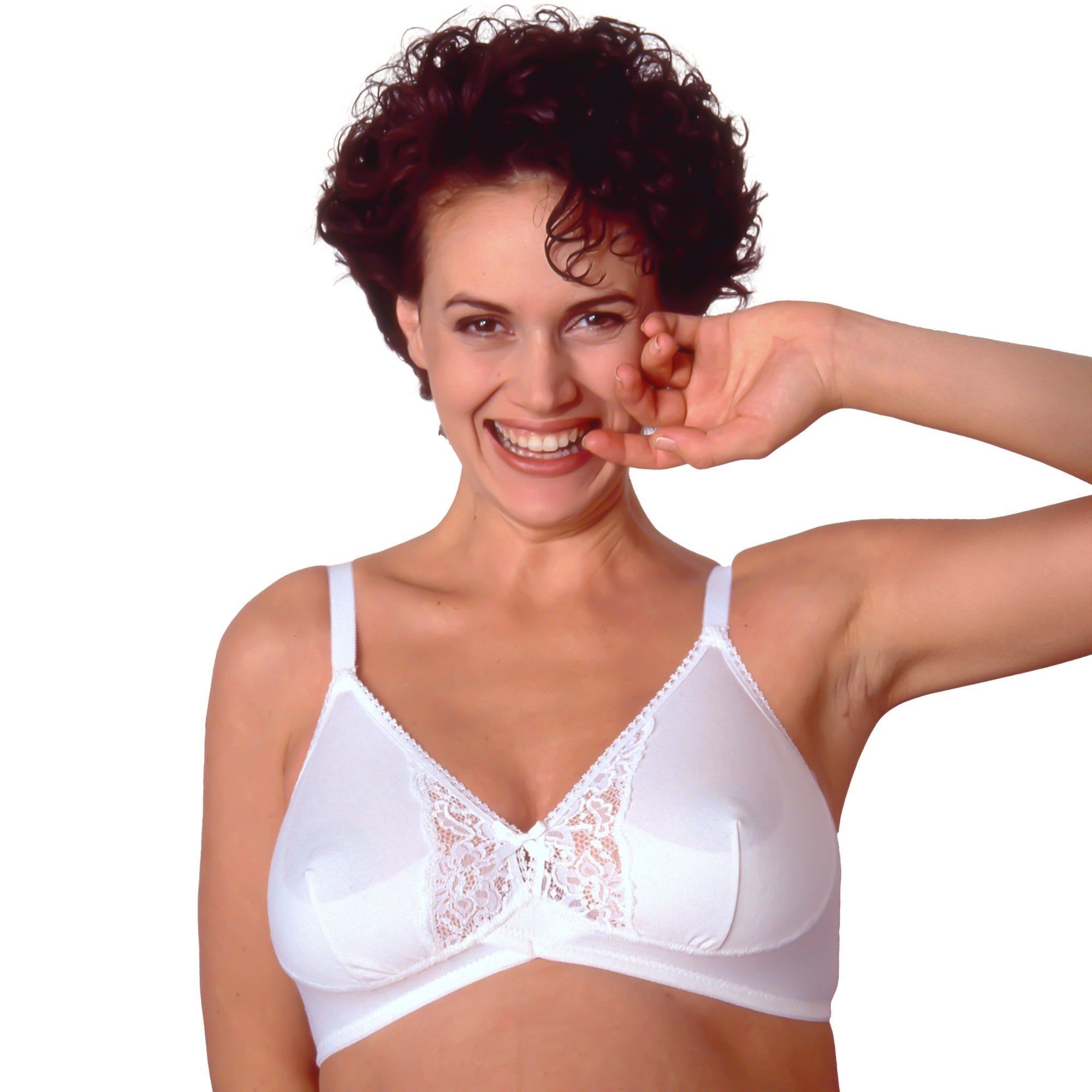 Vrouw draagt witte zwangerschapsbeha met kant. Katoen, cup C. Verstelbare bandjes, kanten detail. Glimlacht.