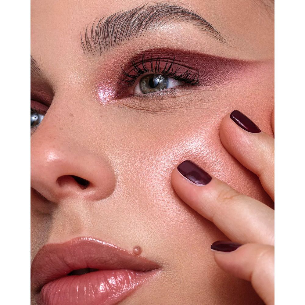 Close-up van een gezicht met make-up. Lippen, ogen en nagels in donkere tinten.