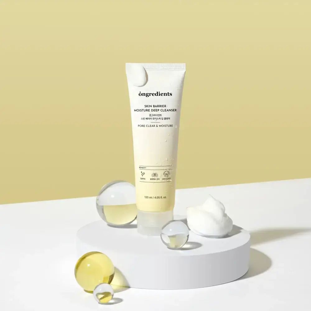 Crèmekleurige tube op voetstuk. Ballen en schuim ernaast. Opschrift: Skin Barrier Moisture Deep Cleanser. 120 ml.