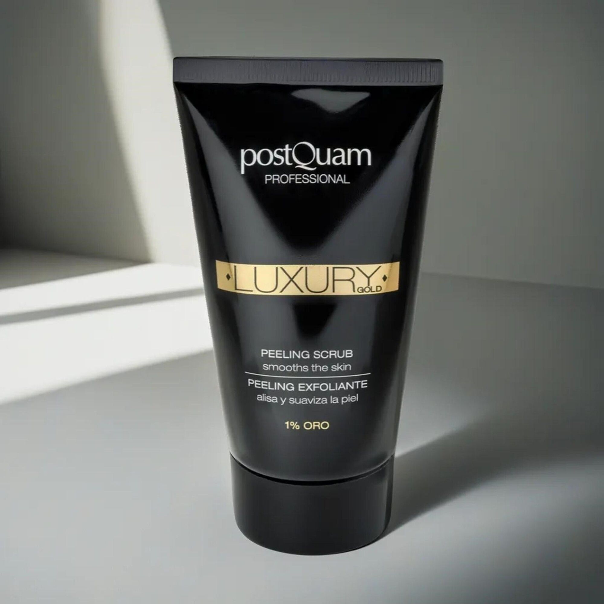 Zwarte tube "Postquam Professional Luxury Gold". Tekst: Peeling Scrub, 1% Oro. Zwarte dop. Op lichte achtergrond.