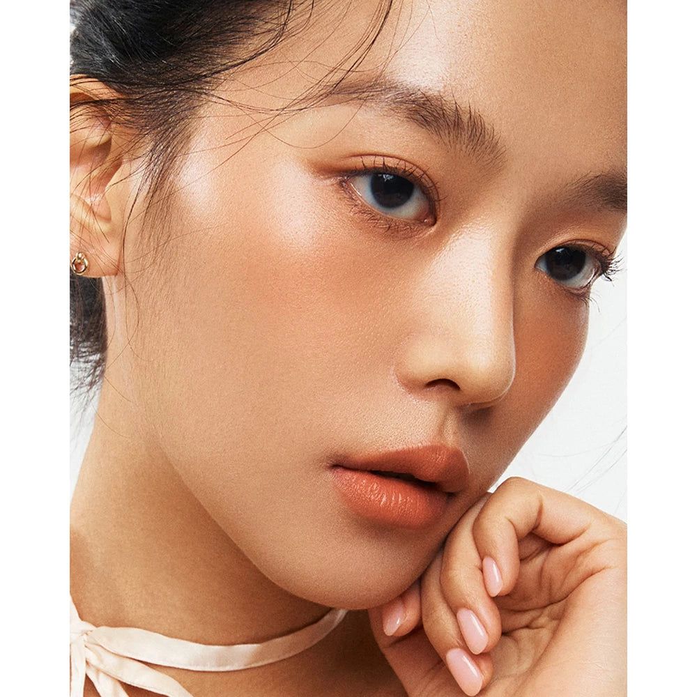 Gros plan sur un visage avec du blush sur les joues. La peau a un léger éclat.