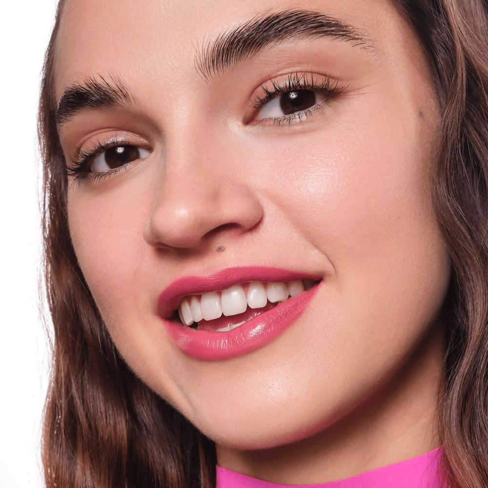 Portrait d'une femme avec des lèvres roses. Elle sourit.