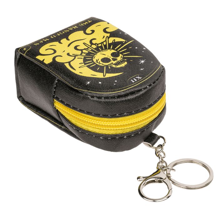 Zwarte mini-portemonnee met gele rits, maan- en doodskopmotief en sleutelhanger.