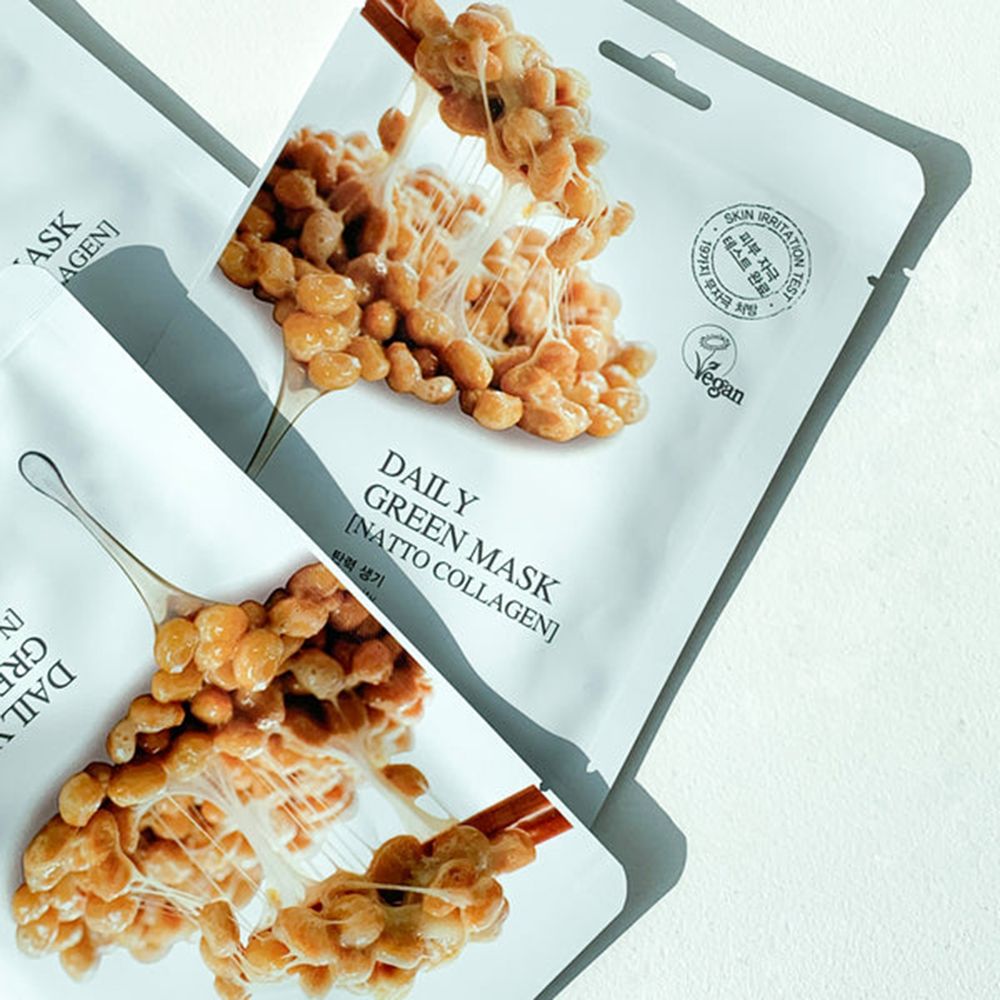 Deux masques en tissu blancs avec illustration et texte. Label vegan. Texte: Daily Green Mask [Natto Collagen].