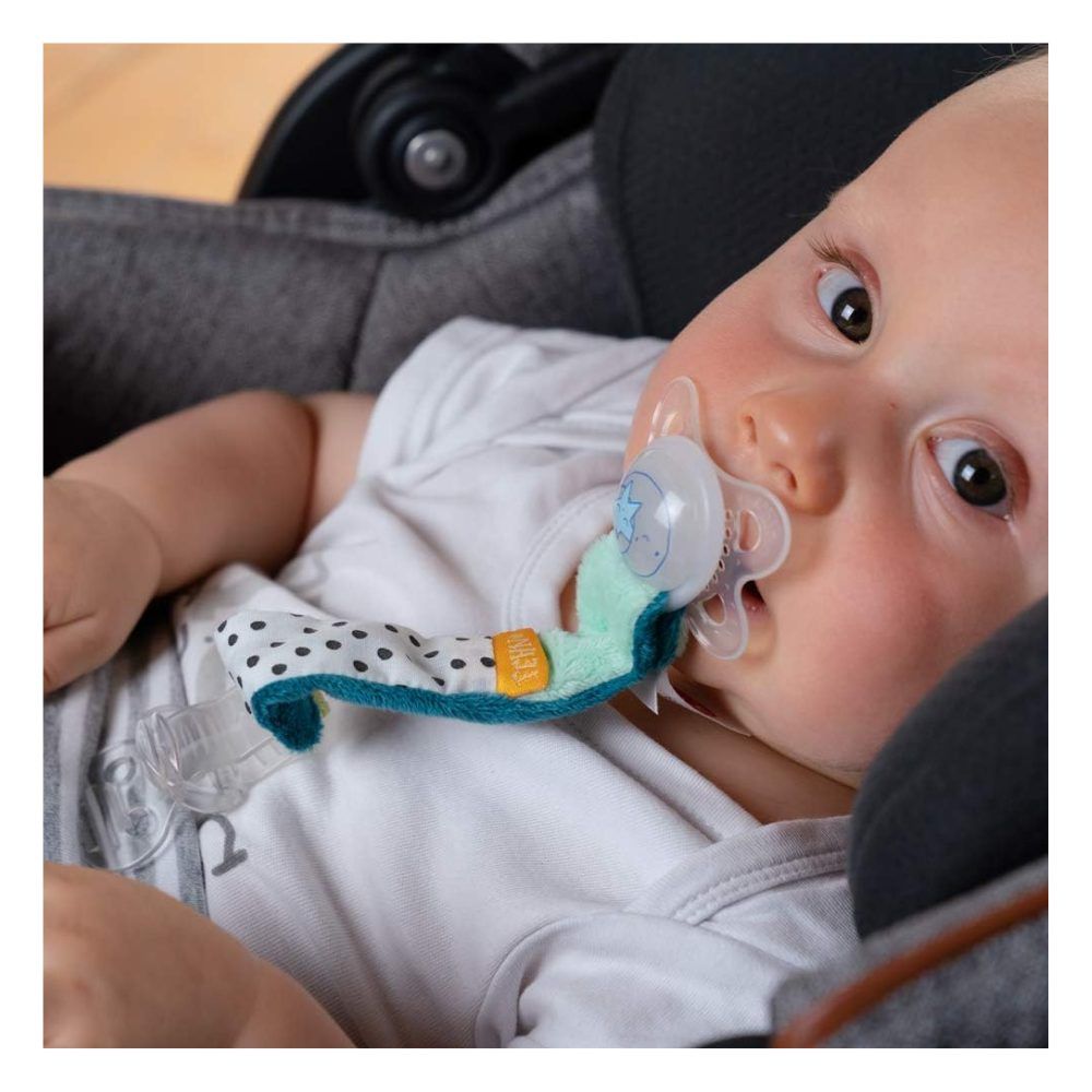 Baby met speen en speenketting Minze. Baby in autostoel. Speen in de mond.
