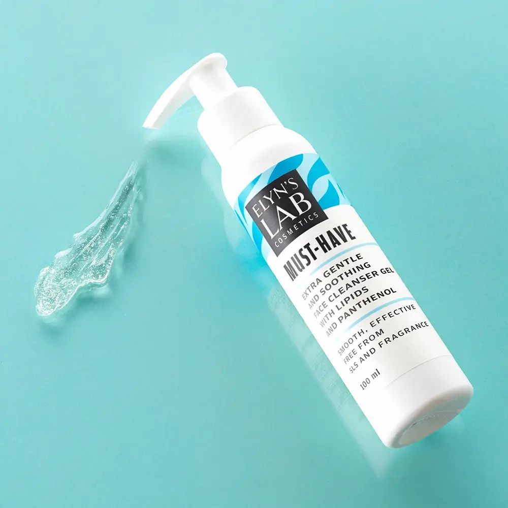 Witte fles met blauw etiket. Tekst: ELYN'S LAB, MUST-HAVE, gezichtsreinigingsgel. Naast een spoor van gel.