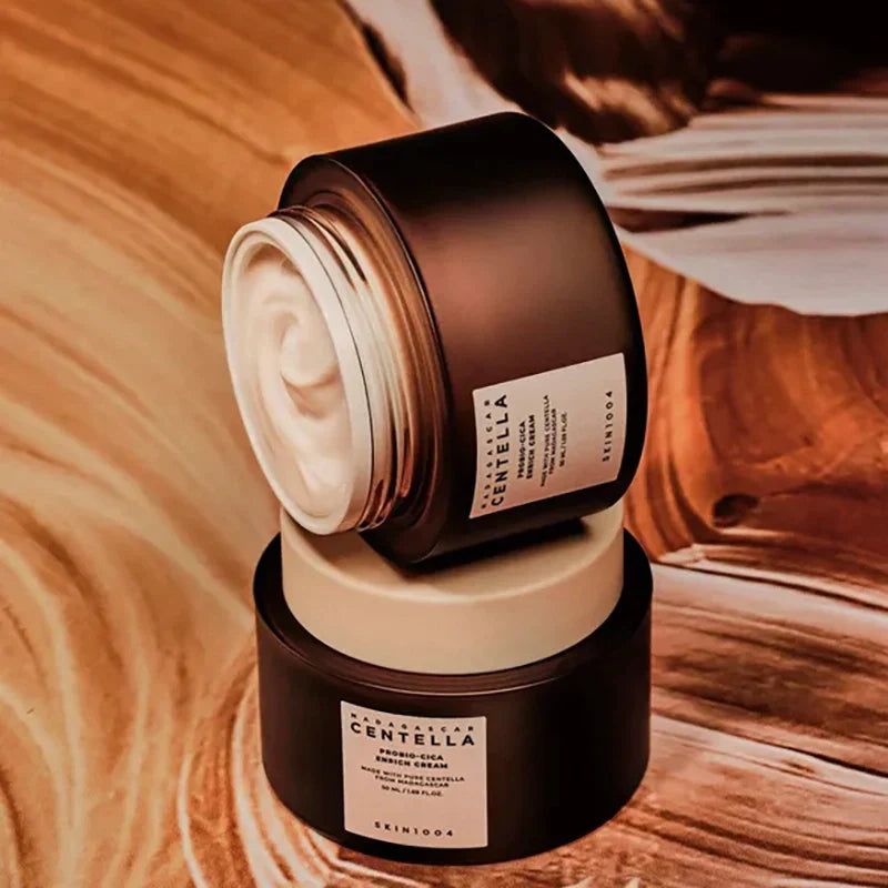 Deux pots de crème bruns avec couvercles blancs, empilés. Étiquette avec texte: MADAGASCAR CENTELLA, SKIN1004.