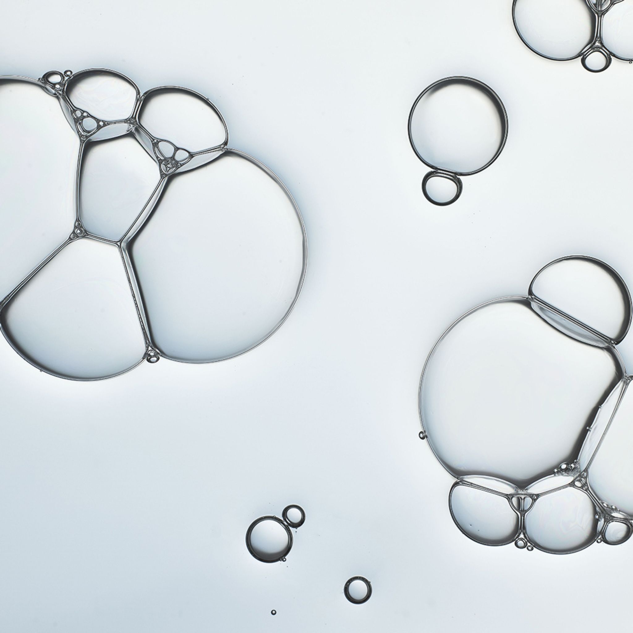 Close-up van zeepbellen. Verschillende transparante bellen van verschillende groottes op een lichte achtergrond.