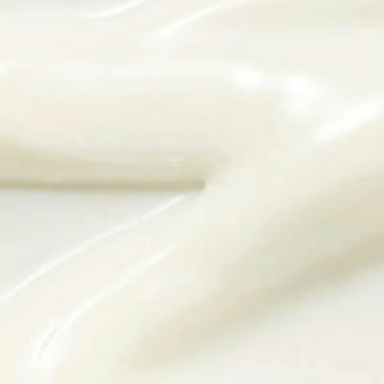 Close-up van een witte, glanzende crème. De textuur is glad en romig.