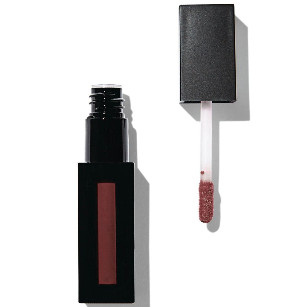 Tube de gloss noir avec bouchon ouvert et applicateur. L'applicateur montre une couleur brun mat. Le récipient est rectangulaire.