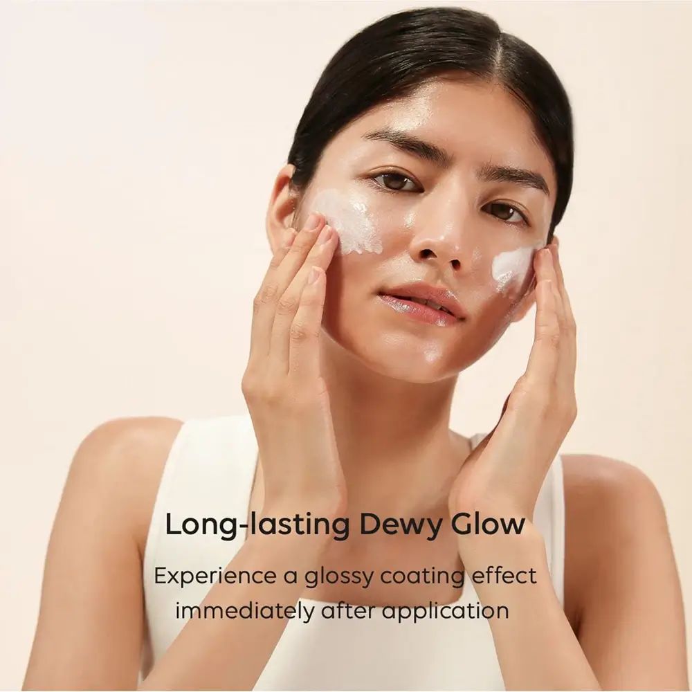 Femme appliquant de la crème sur son visage. Texte : Long-lasting Dewy Glow. Expérimentez un effet brillant.