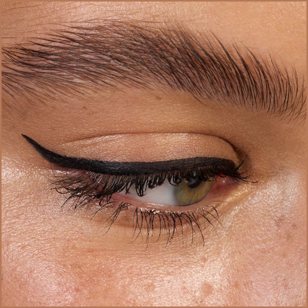 Gros plan sur un œil avec une aile d'eyeliner noir.