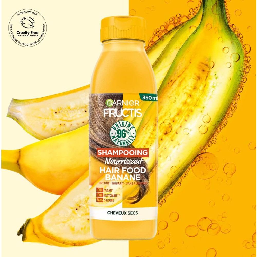 Gele fles Garnier Fructis shampoo. Opschrift: Hair Food Banane, 96% natuurlijke ingrediënten. Vegan, recyclebaar, zonder siliconen. Met bananen.