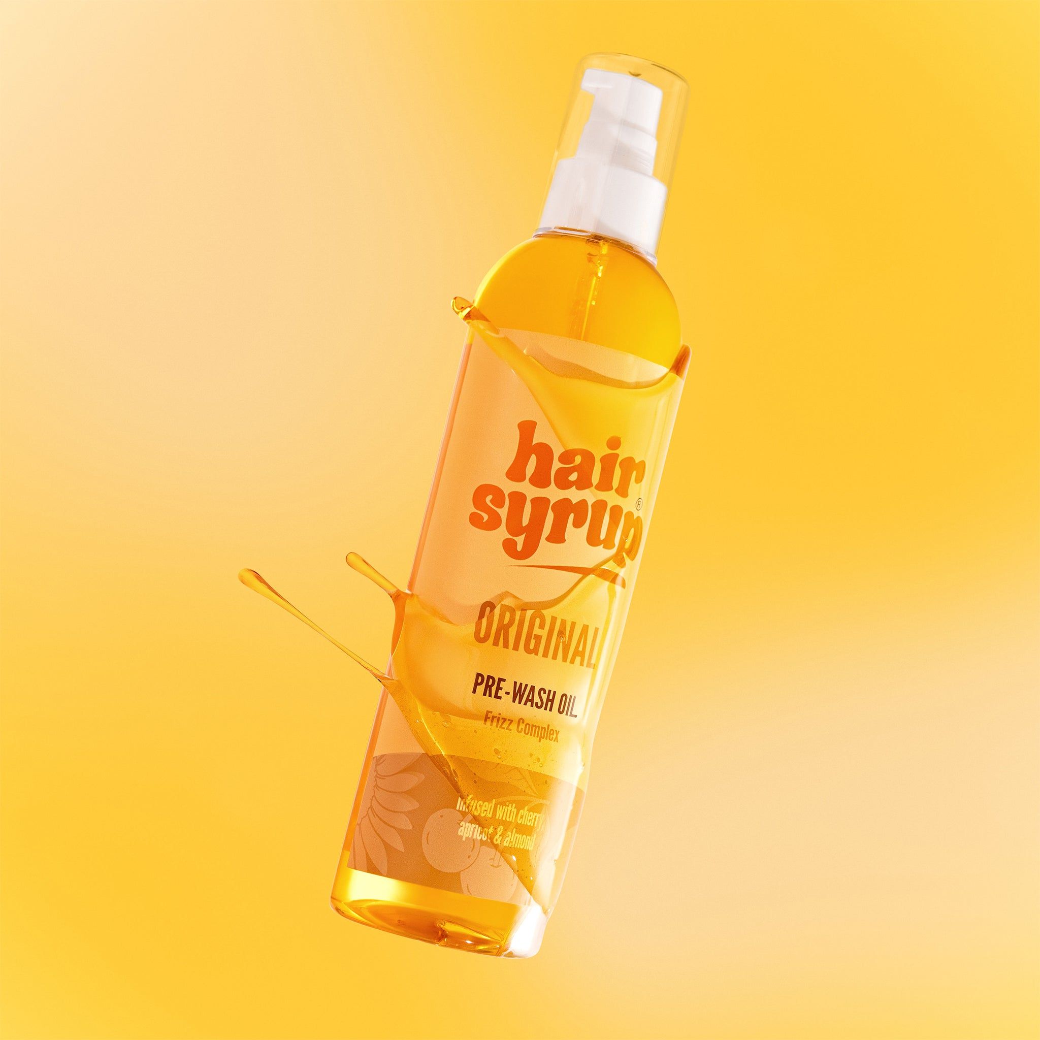 Hair Syrup The Original fles met spatten van vloeistof. Gele achtergrond.
