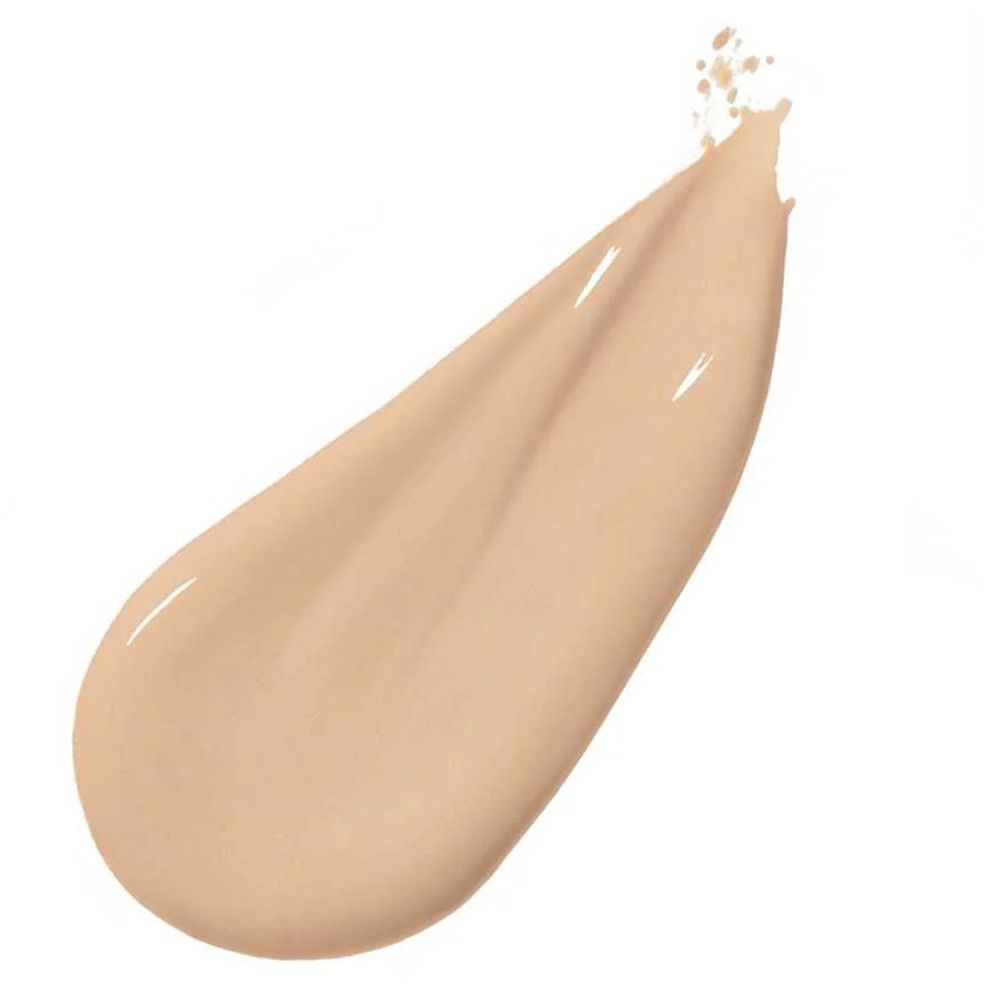 Lichte vloeibare foundationkleur. Druppelvormige applicatie op witte achtergrond. Glanzende textuur.