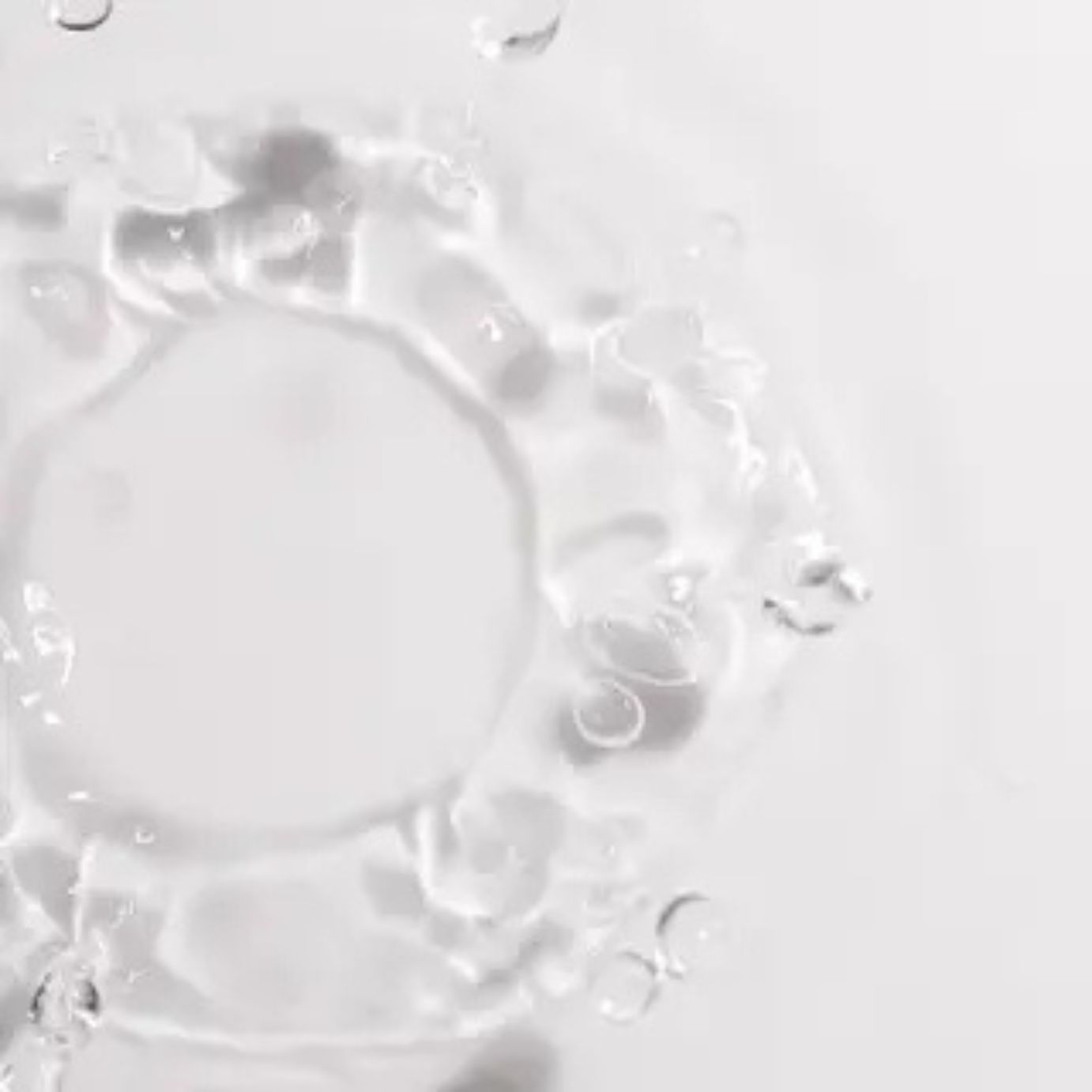 Gros plan sur l'eau. Disposition circulaire des ondulations de l'eau. Fond blanc.