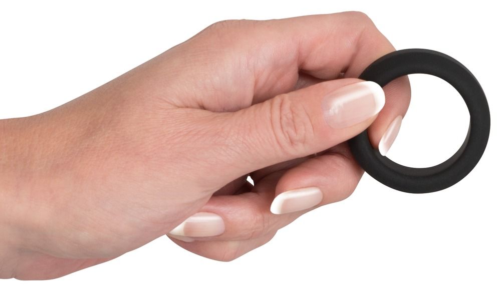 Anneau noir et souple en silicone, tenu par une main.