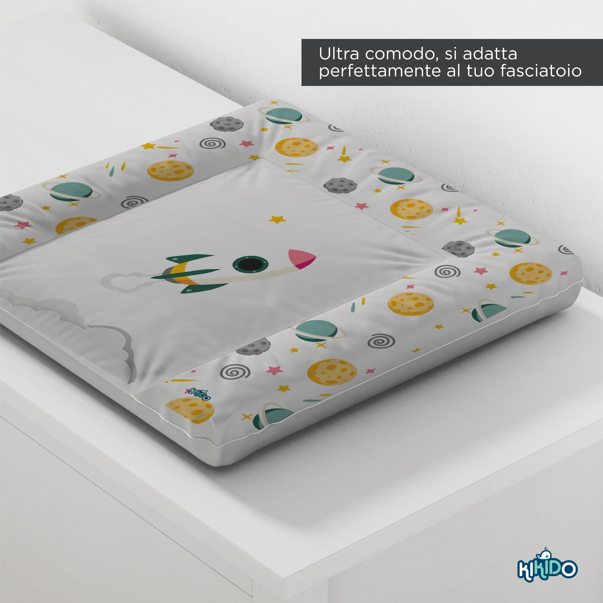 Zacht aankleedkussen met ruimtemotief. Geplaatst op een wit oppervlak. Kikido-logo rechtsonder.