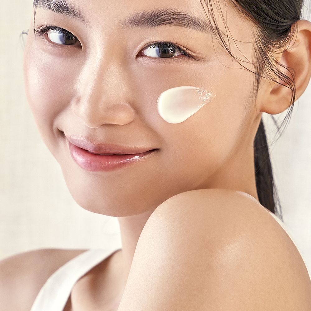 Gezicht van een vrouw met een stip PURITO Wonder Releaf Centella Daily Sun Lotion.