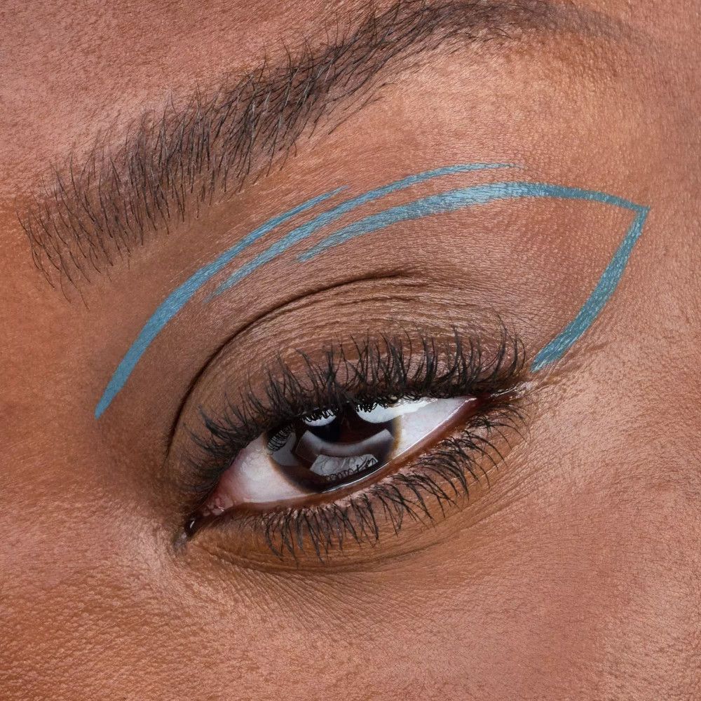Œil avec un design d'eyeliner turquoise en forme d'aile.