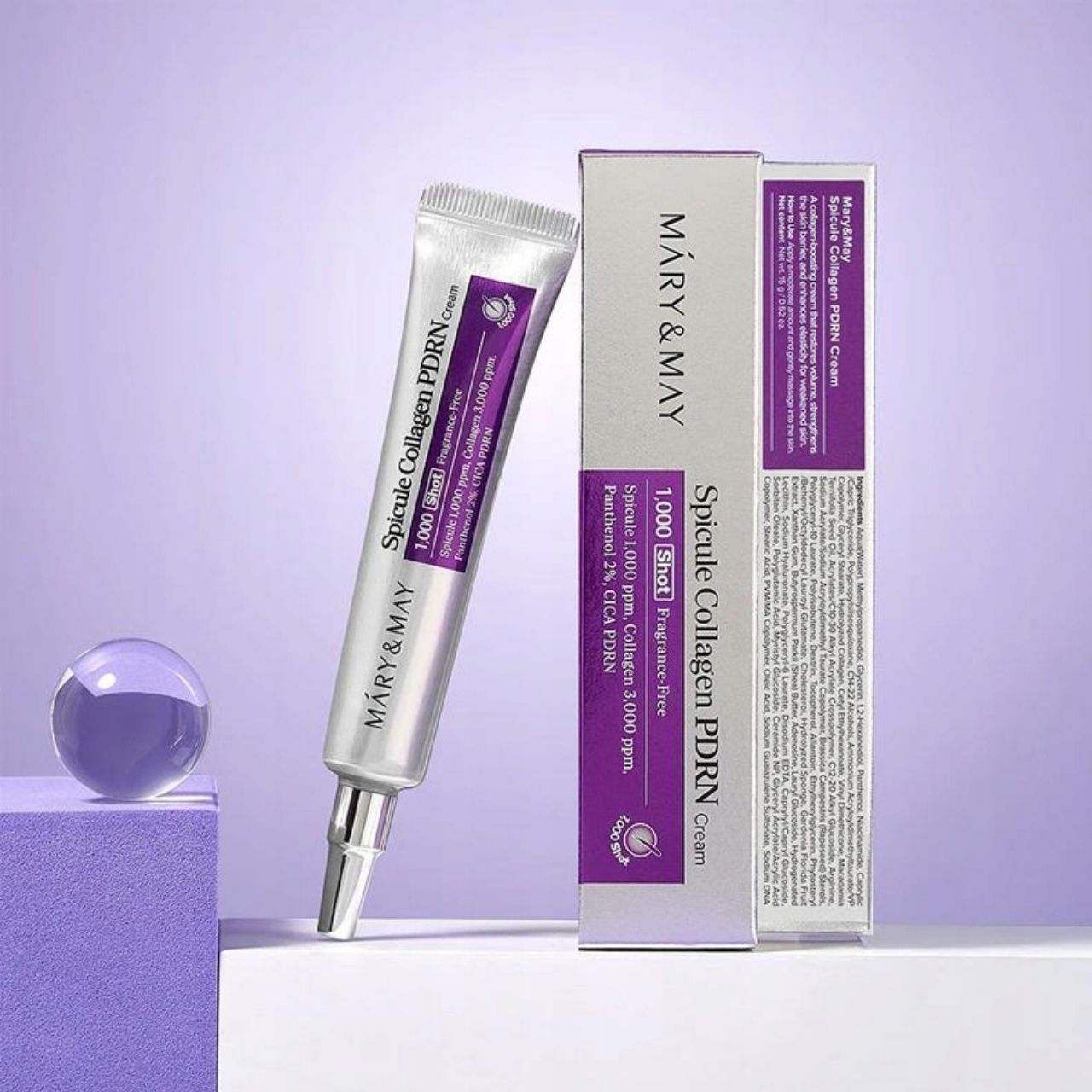 Tube et emballage carton de Mary&May Spicule Collagen PDRN Cream à côté d'éléments décoratifs.
