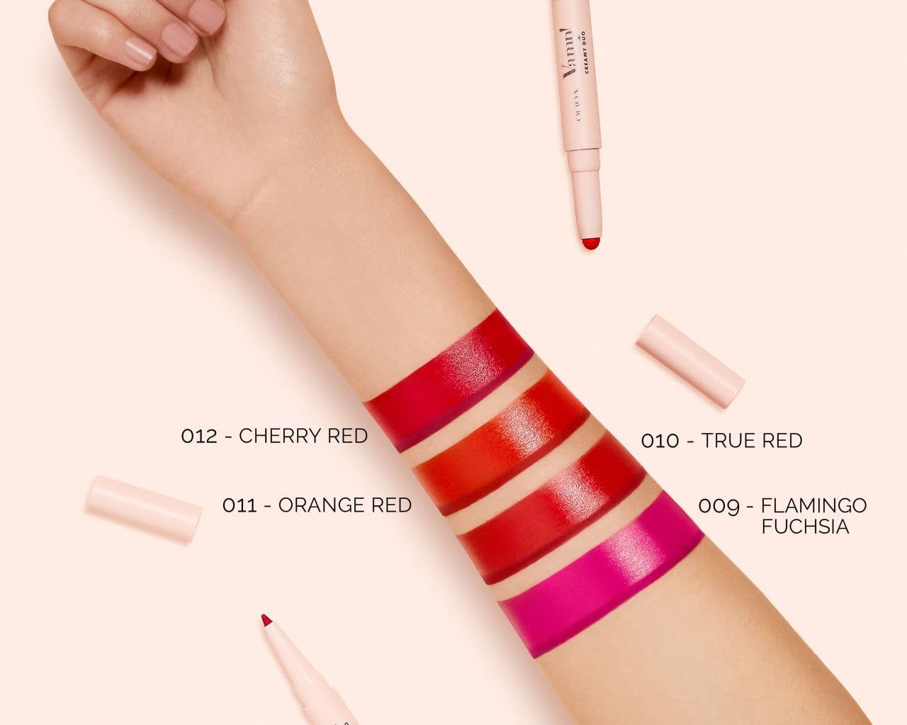 Arm met rode en roze lipstick-swatches. Labels: 012 Cherry Red, 011 Orange Red, 010 True Red, 009 Flamingo Fuchsia.