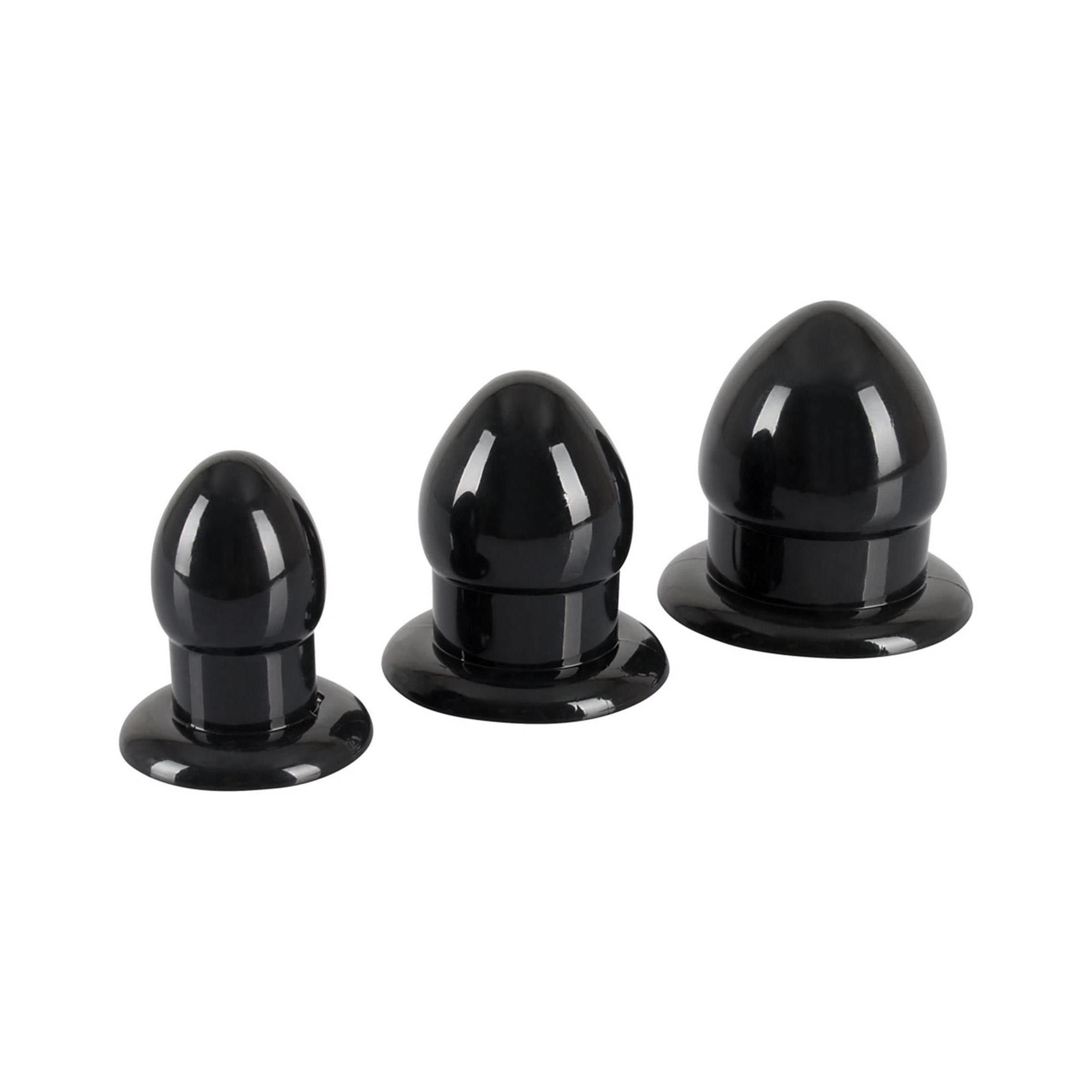 Trois plugs d'étirement anal noirs de différentes tailles côte à côte.