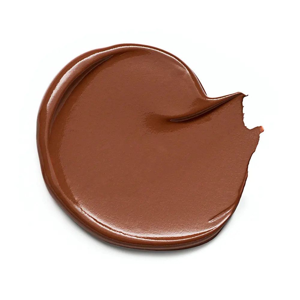 Tache de correcteur brun sur fond blanc. Texture brillante avec une petite encoche.