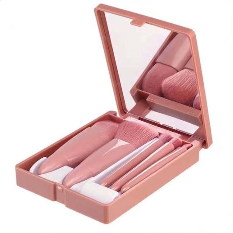 Set de pinceaux de maquillage de voyage rose avec miroir dans son étui ouvert.
