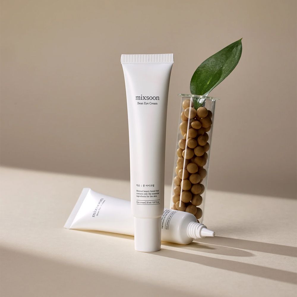 Deux tubes blancs de Mixsoon Bean Eye Cream, dont un avec des fèves de soja et une feuille.