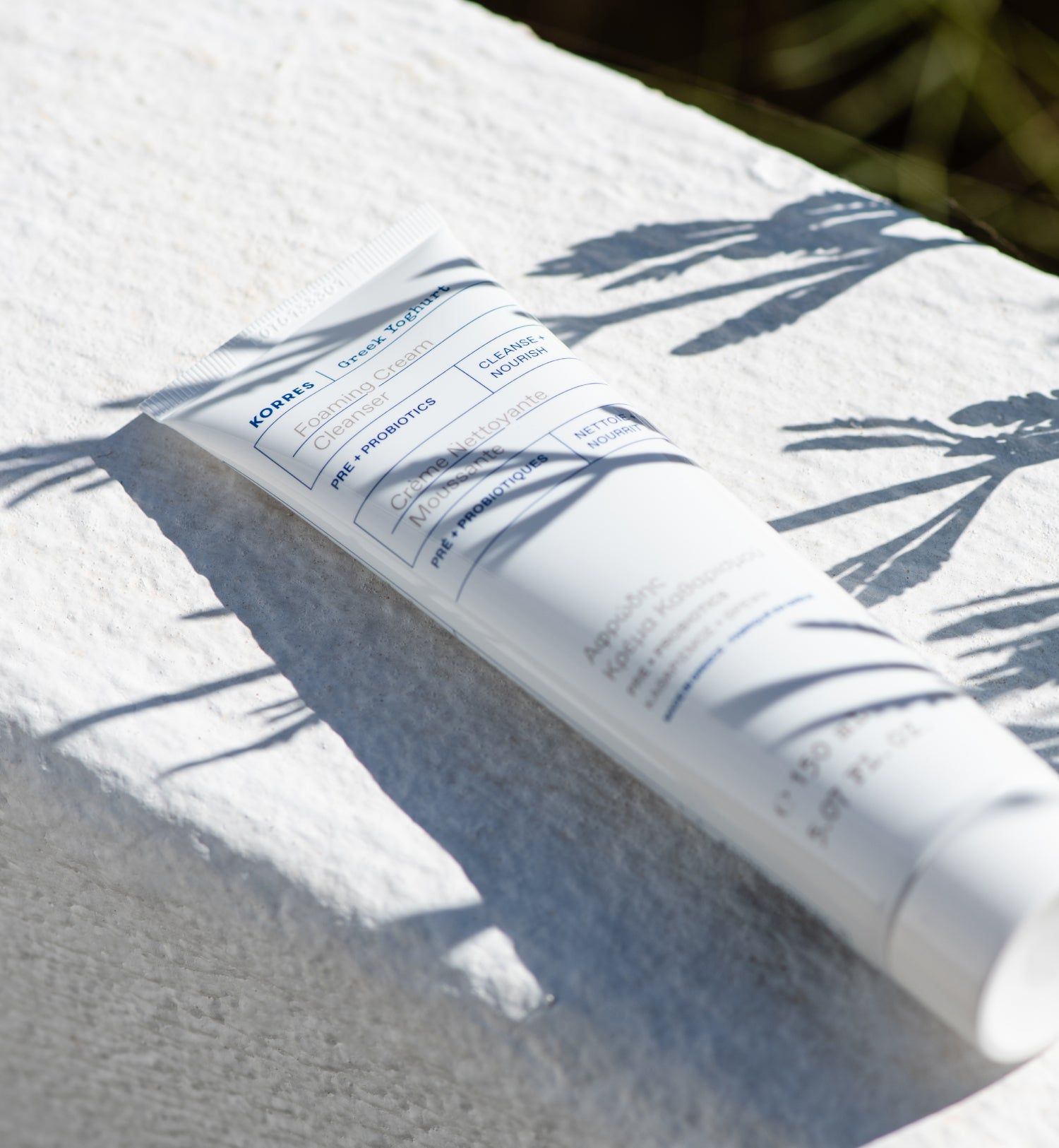 Tube blanc avec texte. Posé sur serviette blanche, ombres.