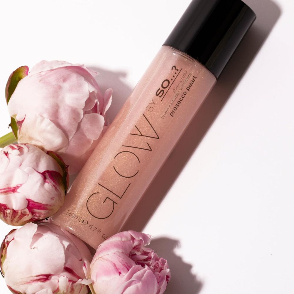 Brume parfumée Prosecco Pearl, entourée de fleurs roses. Produit avec bouchon noir, inscription Glow et By So...?