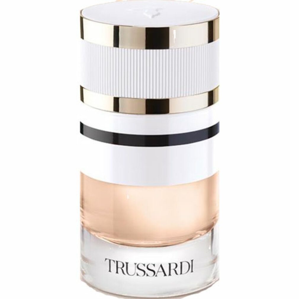 Parfumfles. Cilindrisch, transparant, wit, goud en zwart. Opschrift: Trussardi. Vloeistof: lichtroze.