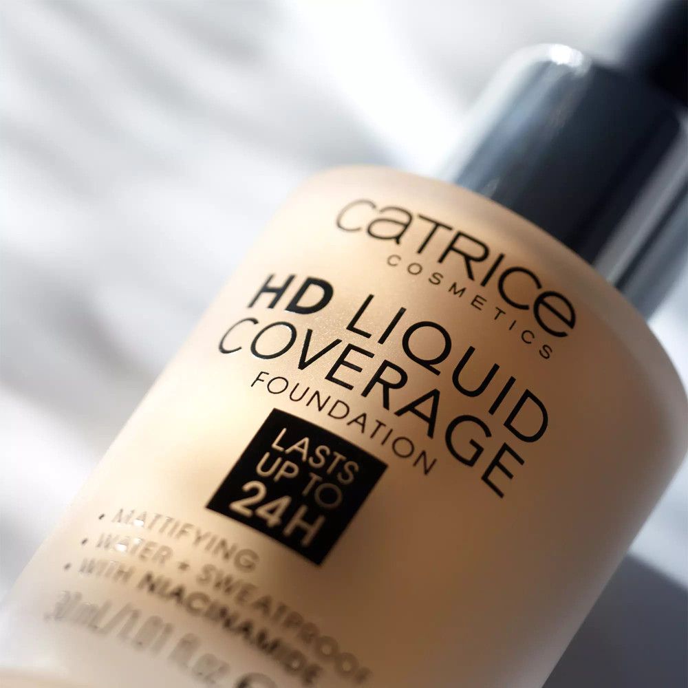 Close-up van een foundationfles. Opschrift: Catrice, HD Liquid Coverage Foundation, blijft tot 24 uur zitten.