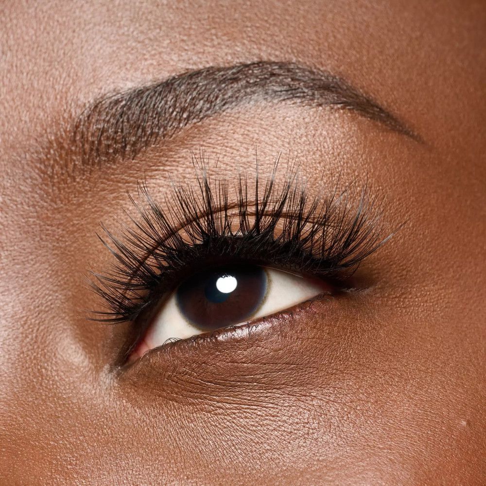 Œil avec faux cils appliqués. Les cils sont noirs et allongent les cils naturels.