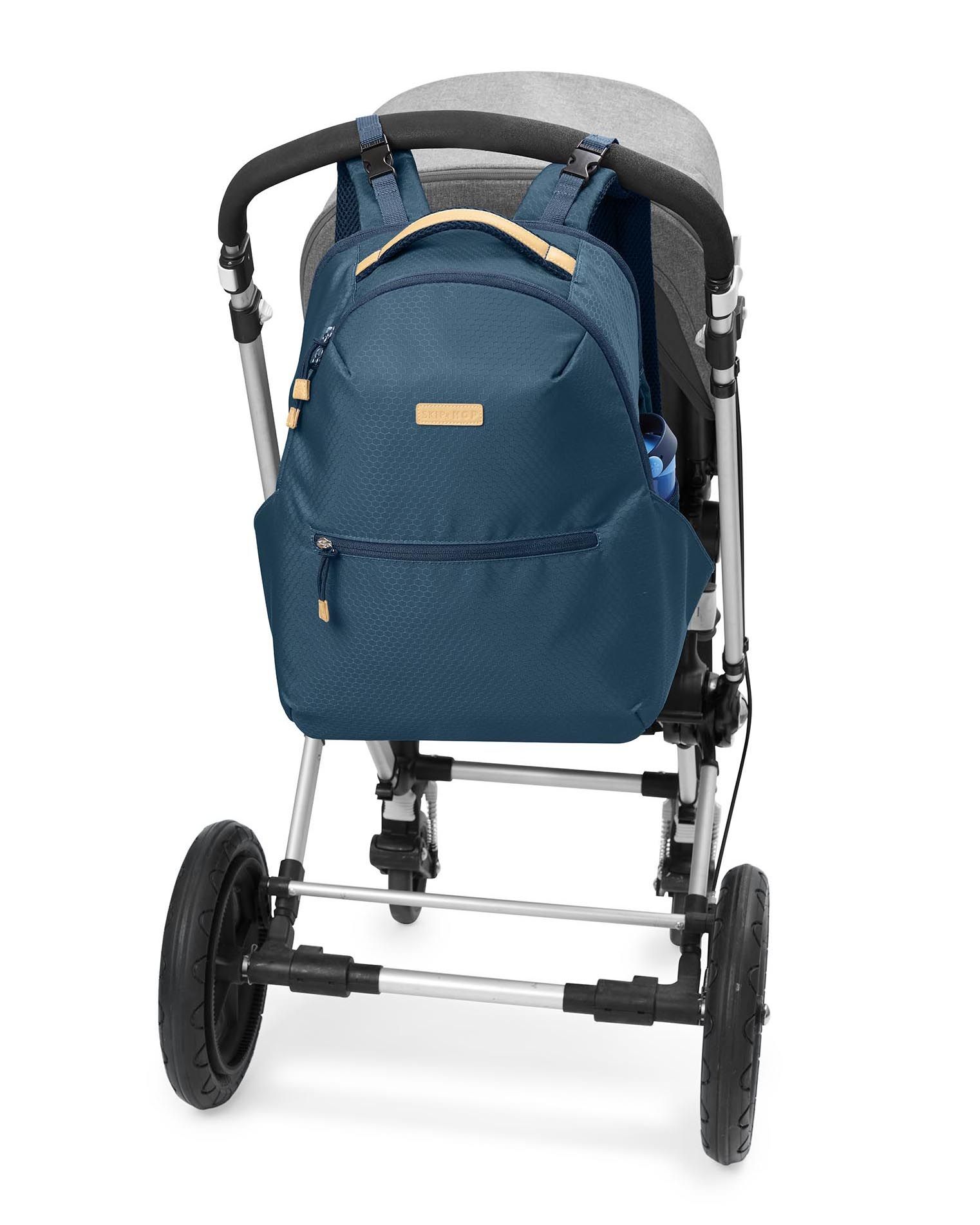 Donkerblauwe luiertas bevestigd aan een kinderwagen. Gele accenten. Flessenhouder.