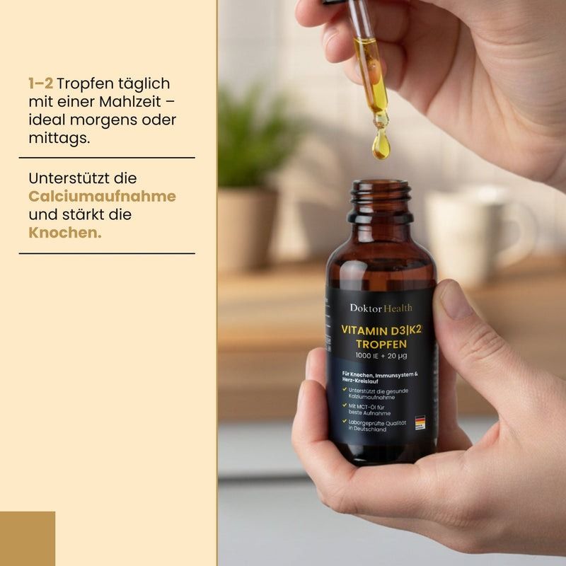 Mains tenant un flacon en verre brun avec pipette. Des gouttes tombent dans le flacon. Inscription : Vitamin D3 + K2 Tropfen.