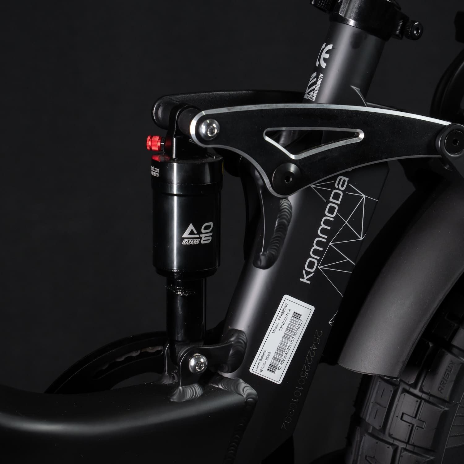 Zwart fietsframe met Kommoda-opschrift. Veersysteem en rode accenten.