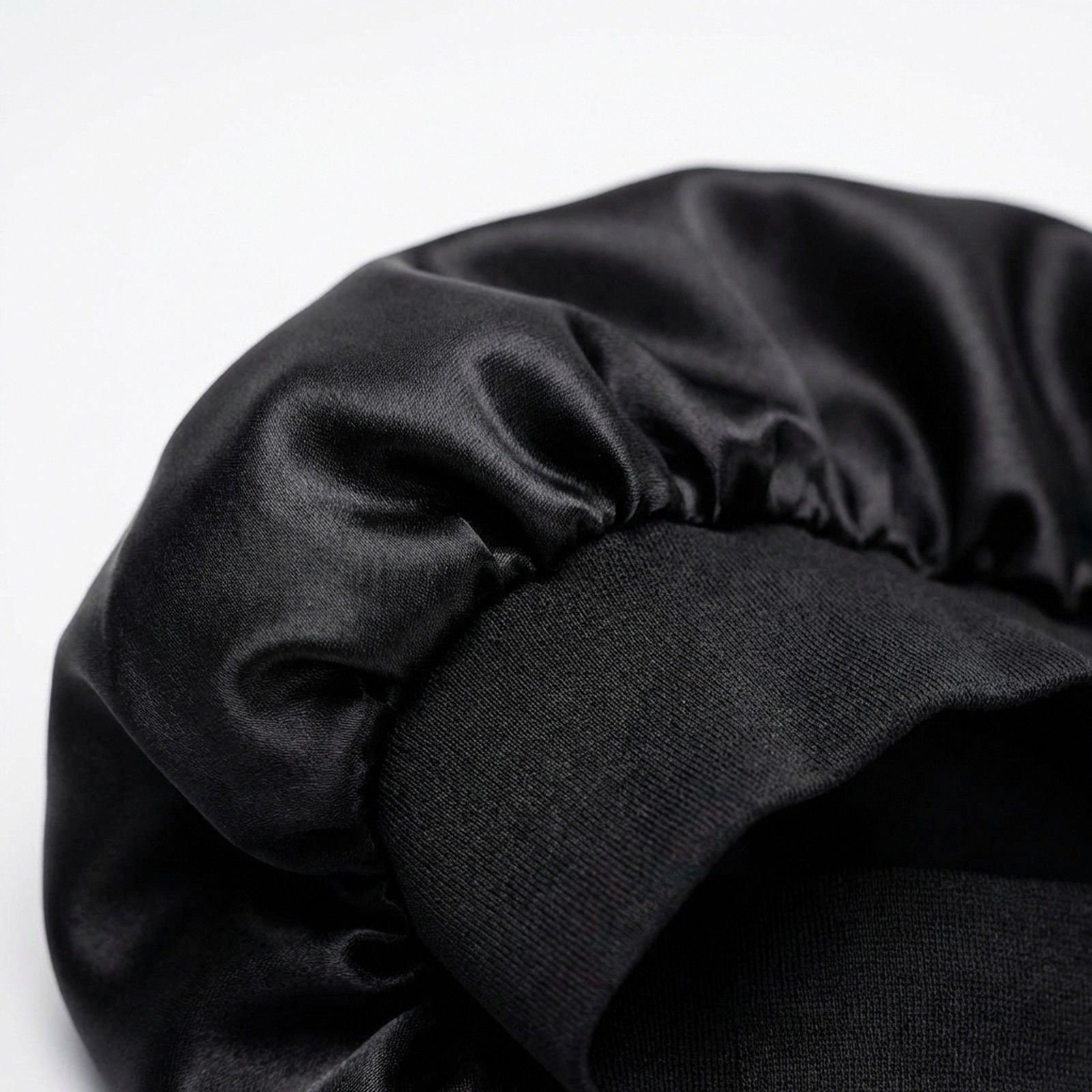 Bonnet de nuit en satin noir avec bordure élastique.