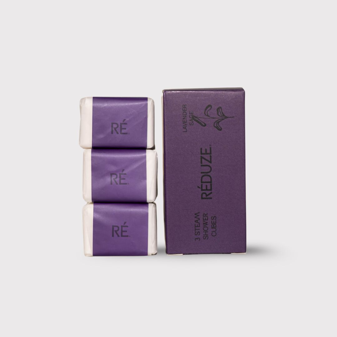 Drie doucheblokjes verpakt in papier, naast een paarse doos met RÉDUZE-logo.