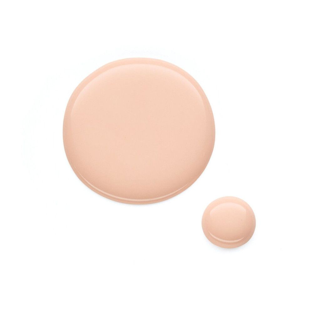 Deux gouttes de vernis à ongles rose clair sur fond blanc. Une grande et une petite goutte.