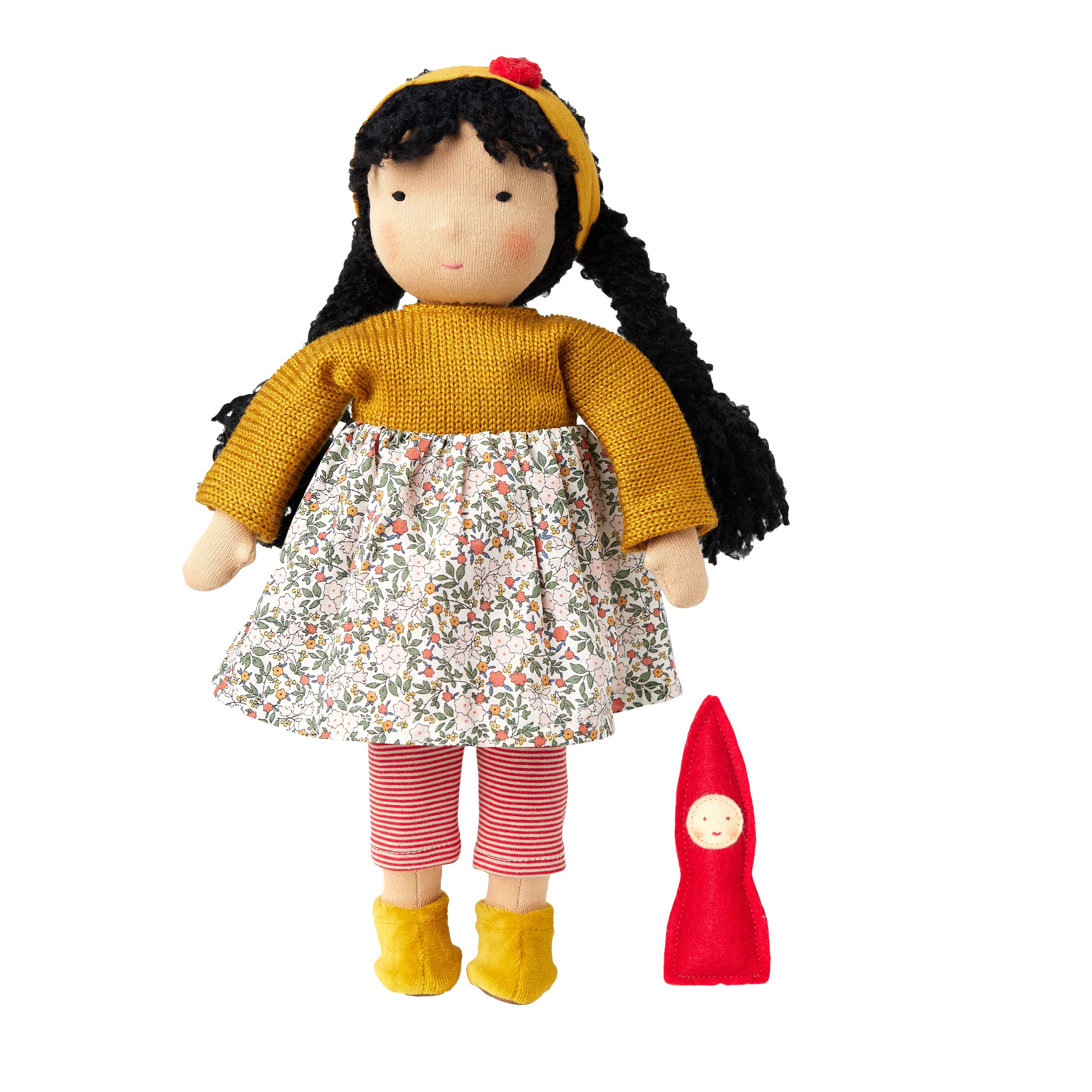 Stoffen pop met gele trui, bloemenjurk, rood-wit gestreepte broek en gele schoenen. Daarnaast een rode stoffen figuur.