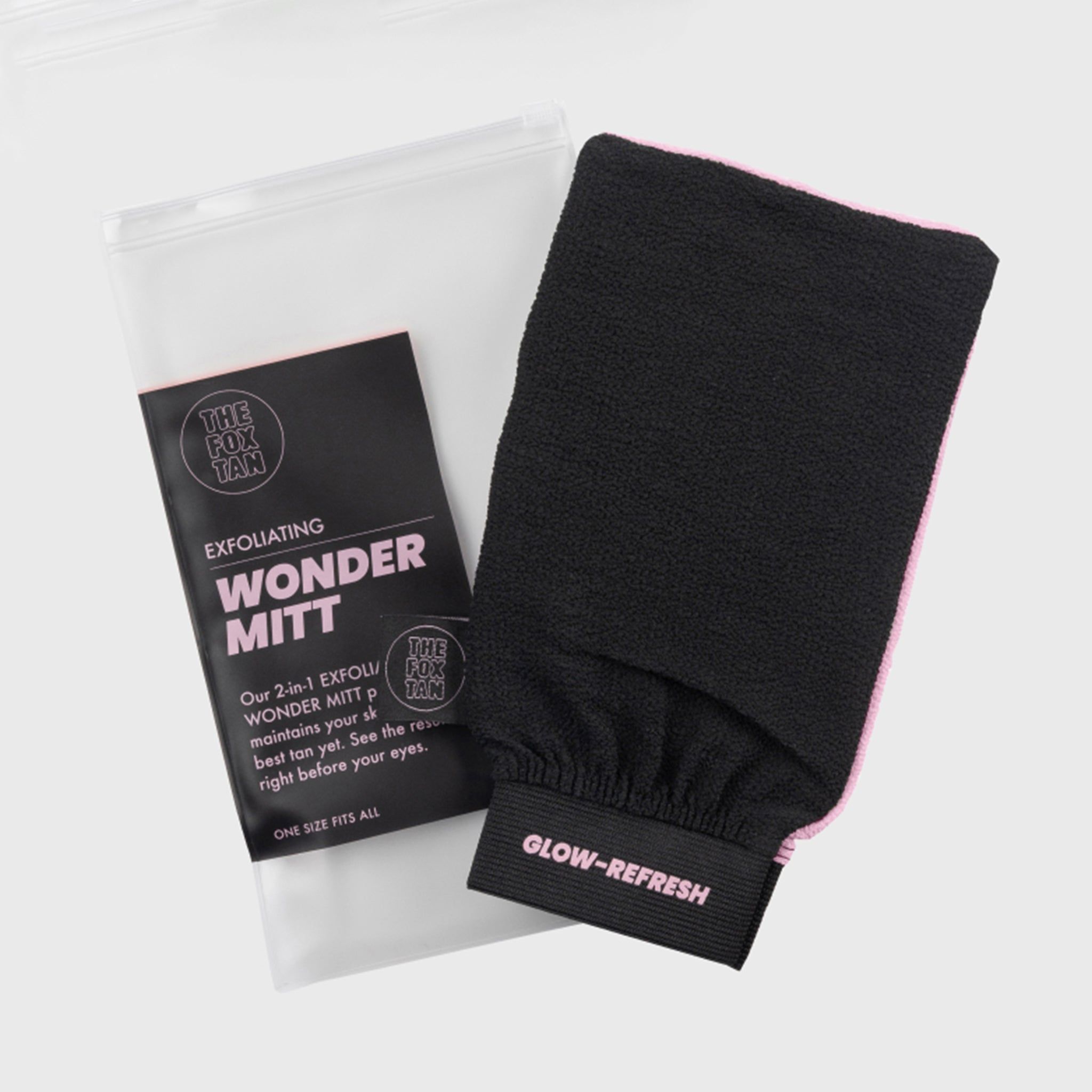 Gant exfoliant noir avec bord rose et texte. Emballage avec informations sur le produit inclus.